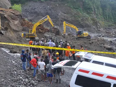Petugas dibantu alat berat berusaha mencari korban tanah longsor di Magelang, Senin (18/12). Menurut pejabat setempat, delapan penambang tewas akibat longsor di lereng gunung berapi di pulau Jawa. (AFP Photo)