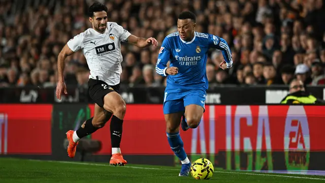 Pemain Real Madrid Kylian Mbappe (kanan) berebut bola dengan pemain Valencia Eray Comert