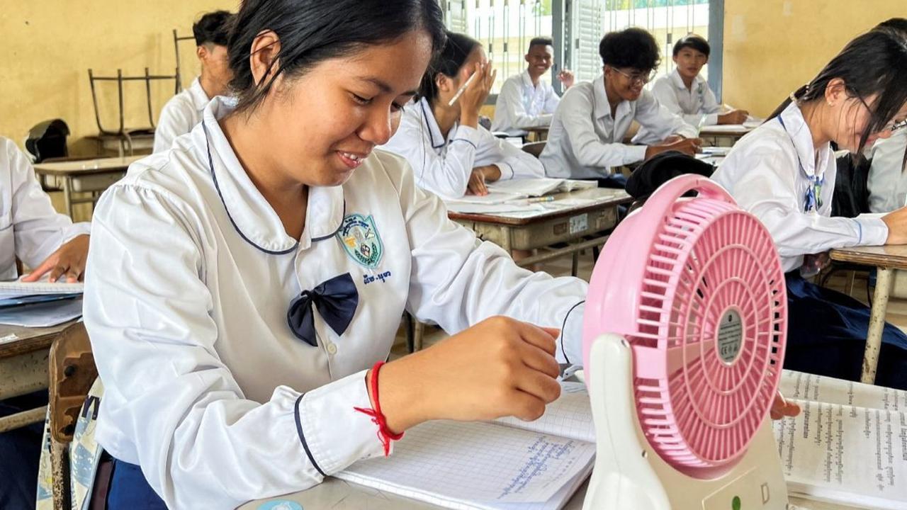 Seorang murid menggunakan kipas angin untuk menyegarkan diri selama kebiatan belajar di sebuah sekolah di Phnom Penh, Kamboja, pada Kamis (2/5/2024). Gelombang panas yang membuat suhu naik ekstrem tengah 'memanggang' Kamboja.&nbsp;REUTERS/Cha Tha Lach