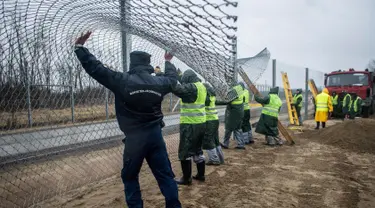 Narapidana mulai memasang pagar kedua di perbatasan Hungaria - Serbia, dekat Kelebia, 1 Maret 2017. Pagar perbatasan itu dilengkapi alat kejut listrik, sensor panas, kamera dan pengeras suara untuk mengusir para imigran. (Sandor Ujvari/MTI via AP)