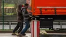 Dua Imigran berusaha membuka pintu truk di A25 autoroute, Steenvoorde, Prancis (27/2). Para imigran ini nekat sembunyi saat menghindari kejaran petugas imigrasi. (AFP Photo / Philippe Huguen)