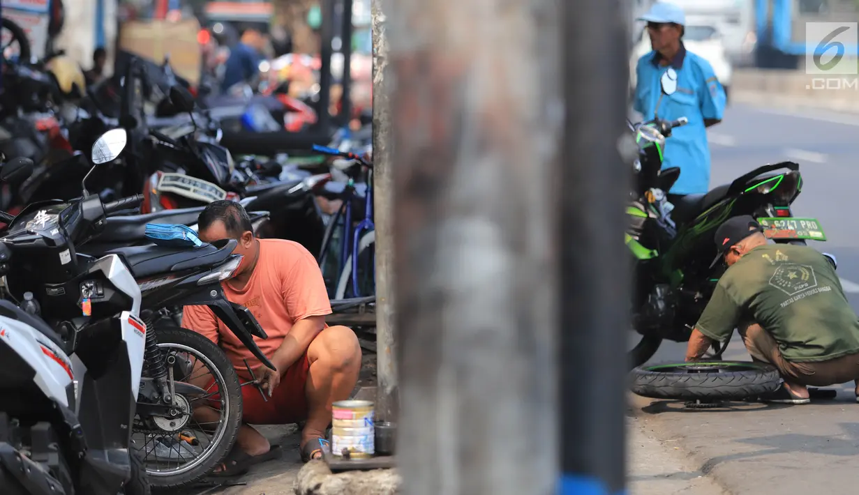 Sejumlah mekanik memperbaiki motor di salah satu bengkel di Otista, Jakarta, Minggu (10/6). Calon pemudik motor mulai memenuhi bengkel guna menyervis atau mengganti suku cadang kendaraan sebelum digunakan untuk mudik Lebaran. (Liputan6.com/Angga Yuniar)