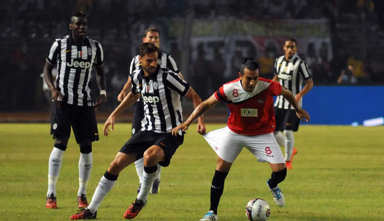 Gelandang Juventus, Fernando Llorente (kedua dari kiri) menarik celana Gustavo Lopez (ISL All Stars) saat berlaga di Stadion GBK Jakarta, (6/8/2014). (Liputan6.com/Helmi Fithriansyah)