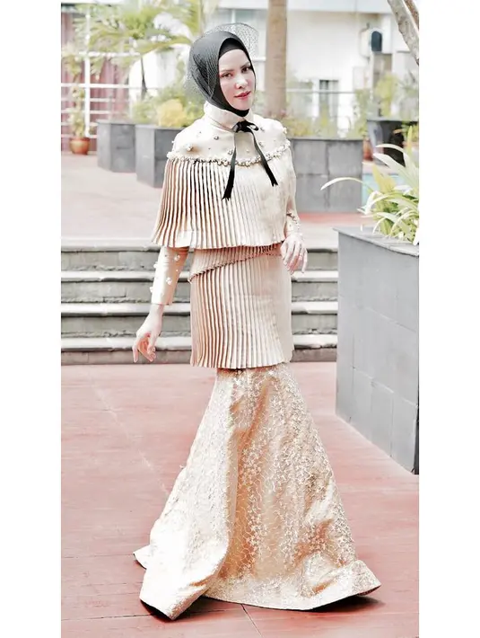 Nah, yang ini juga glamor banget, terlihat dari model dan warna gold pada dress yang dipakai Angel ini. Istri Vicky ini cukup piawai dalam memadukan hijabnya, terbukti dengan caranya memakai kerudung hitam kali ini. (Instagram/angellelga)