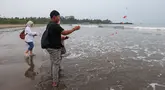 Keluarga menaburkan bunga ke laut dalam prosesi untuk lima jurnalis dan tiga kru kapal Arupadhatu 1 di pantai dekat Dermaga Pegedongan, Banten, Jumat (18/9/2026). Dermaga tersebut menjadi titik awal keberangkatan delapan orang itu pada Senin (7/9/2026). (KLY/Budy Santoso)