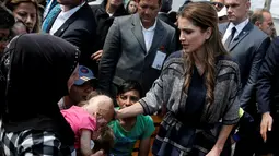 Ratu Rania dari Yordania (kanan) membelai seorang bayi dengan luka bakar saat kunjungannya ke kamp pengungsi Kara Tepe di pulau Yunani, Lesbos, Senin (25/4). (REUTERS/Alkis Konstantinidis)