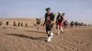 Sejumlah peserta bersaing dalam kejuaraan Marathon des Sables ke-33 tahap kedua di Gurun Sahara, selatan Maroko, Senin (9/4). Tidak hanya berlari menempuh jarak yang sangat jauh, peserta juga mengatasi iklim ekstrem Sahara. (JEAN-PHILIPPE KSIAZEK/AFP)