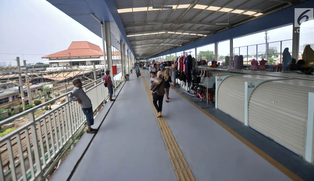 Pengunjung melintasi sejumlah kios pedagang di Skybridge atau jembatan multiguna Tanah Abang, Jakarta, Selasa (11/12). Ada 446 kios di Skybridge Tanah Abang. (Merdeka.com/Iqbal Nugroho)
