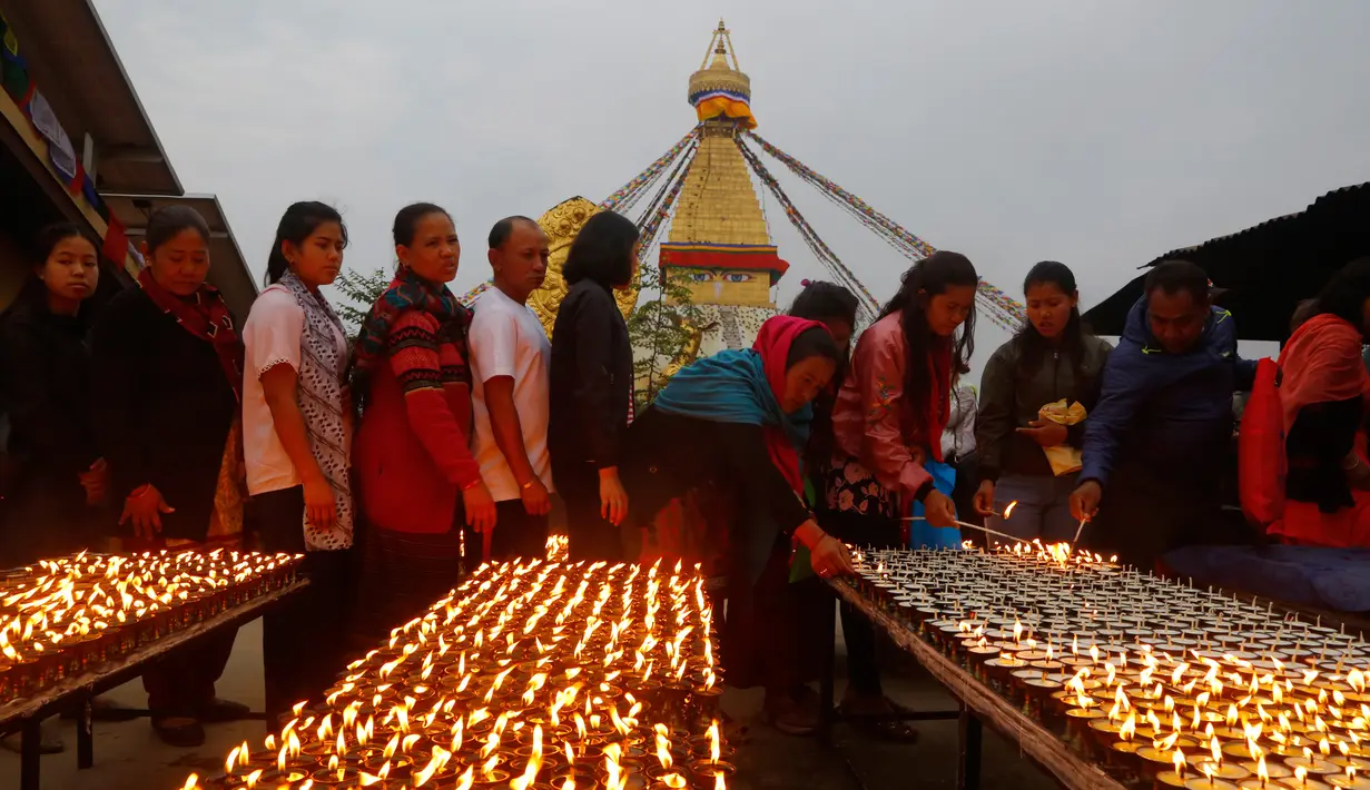 Umat Buddha Nepal berbaris untuk menyalakan lilin saat perayaan Buddha Jayanti atau Buddha purnima di stupa Boudhanath, Kathmandu, Nepal (30/4). (AP/Niranjan Shrestha)