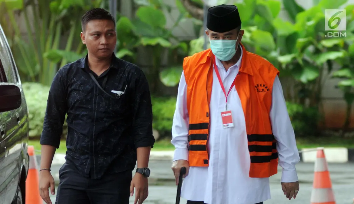 Bupati Bandung Barat Abubakar mengenakan masker dan tongkat berjalan saat tiba di gedung KPK, Jakarta, Selasa (24/4). Abubakar diperiksa perdana pasca penahanan oleh KPK. (Merdeka.com/Dwi Narwoko)