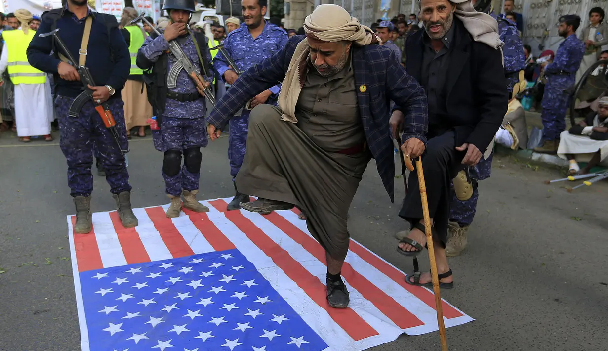 Bendera Amerika Serikat diinjak saat demonstrasi mengecam pembakaran Al-Quran oleh seorang politisi Swedia di ibu kota Sanaa pada 23 Januari 2023. Pemerintah pusat Swedia sudah mengecam aksi Paludan tersebut. (AFP/Mohammed Huwais)