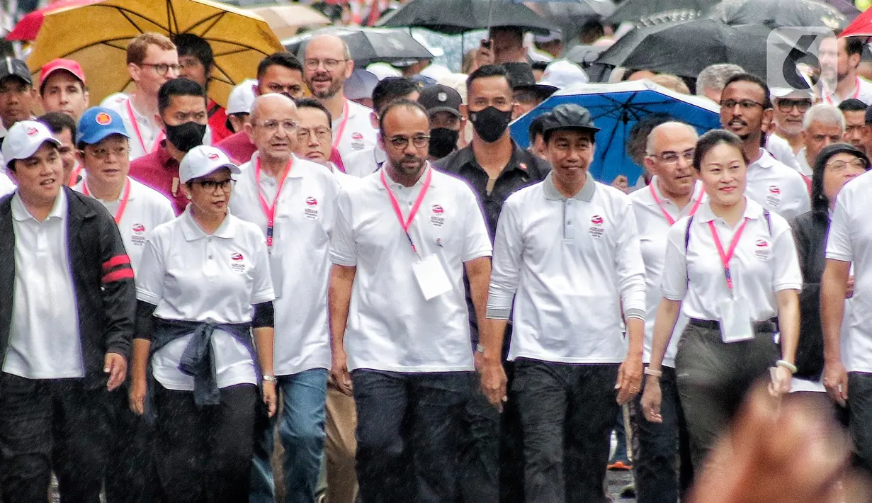 Presiden Joko Widodo (tengah) bersama jajaran menteri dan para duta besar negara-negara anggota Asean serta non-Asean berjalan dalam Parade Asean di Jalan MH. Thamrin, Jakarta, Minggu (29/1/2023). Acara tersebut merupakan 'kick off' keketuaan Indonesia dalam ASEAN 2023 yang puncaknya akan berlangsung dua kali, yakni Konferensi Tingkat Tinggi (KTT) ASEAN pada Mei 2023 di Labuan Bajo, Provinsi Nusa Tenggara Timur (NTT) dan KTT ASEAN Plus di Jakarta pada September 2023. (Liputan6.com/Angga Yuniar)