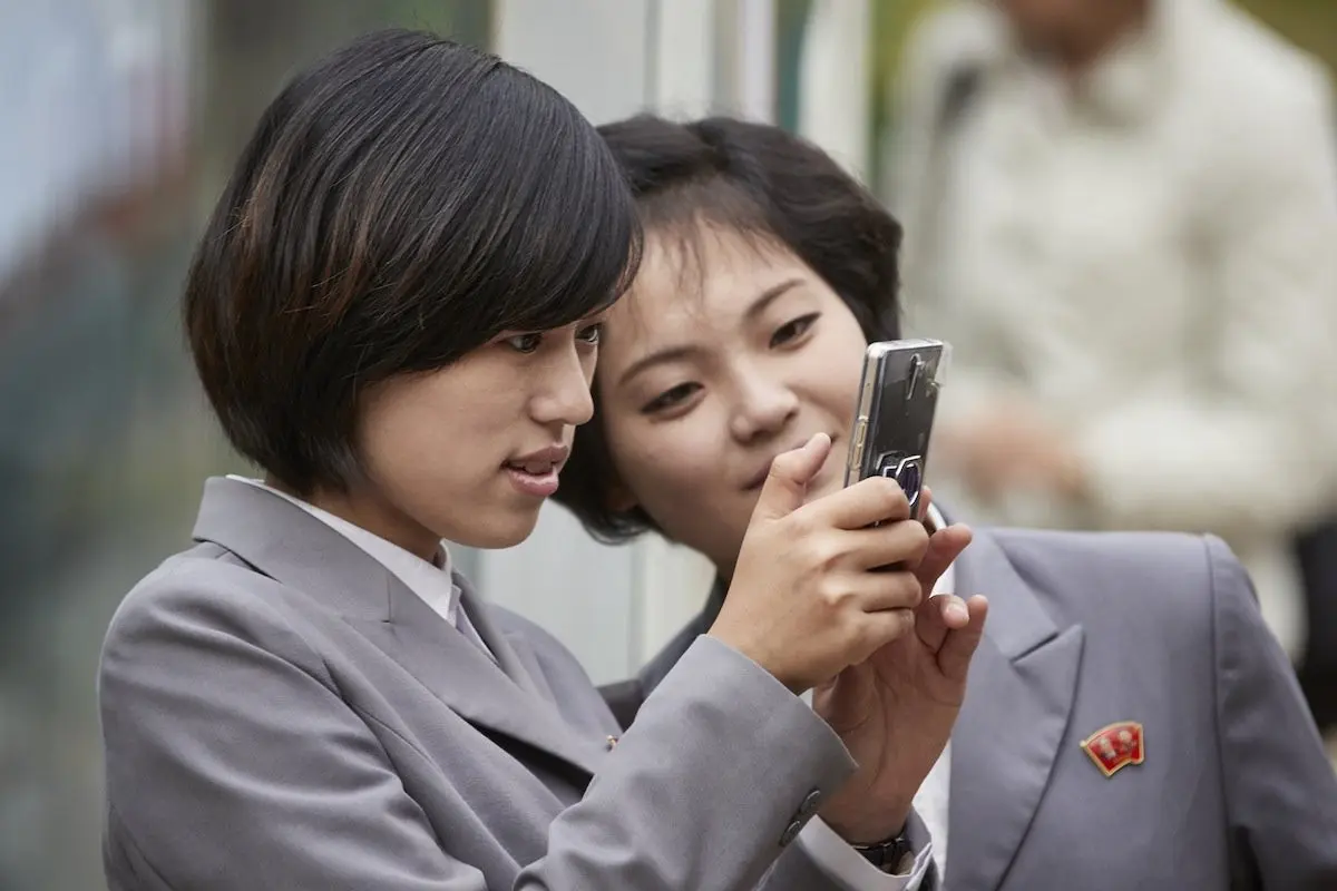 Dua siswa perempuan berseragam sekolah ini tampak sedang asyik menggunakan smartphone mewah di tempat umum (Sumber: Nextshark)