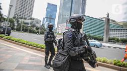 Petugas Brimob dengan senjata lengkap berjaga di kawasan Bundara HI, Jakarta, Kamis (24/12/2020). Pengamanan ini dilakukan guna memberikan pengamanan kepada umat nasrani merayakan malam natal di Jakarta. (Liputan6.com/Faizal Fanani)