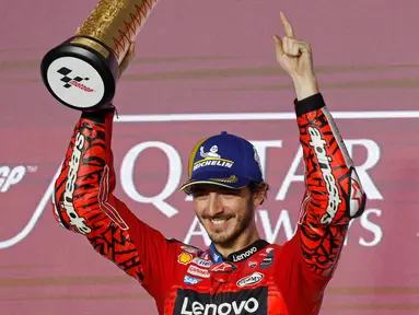 Pembalap Ducati Lenovo Team, Francesco Bagnaia saat merayakan gelar juara di podium MotoGP Qatar di Sirkuit Internasional Lusail, Doha pada 10 Maret 2024. (KARIM JAAFAR/AFP)