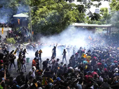 Polisi menggunakan gas air mata untuk membubarkan pengunjuk rasa yang menyerbu kompleks kantor perdana menteri Ranil Wickremesinghe, menuntut dia mengundurkan diri setelah presiden Gotabaya Rajapaksa melarikan diri dari negara itu di tengah krisis ekonomi di Kolombo, Sri Lanka, Rabu (13/7/2022). (AP Photo/Eranga Jayawardena)
