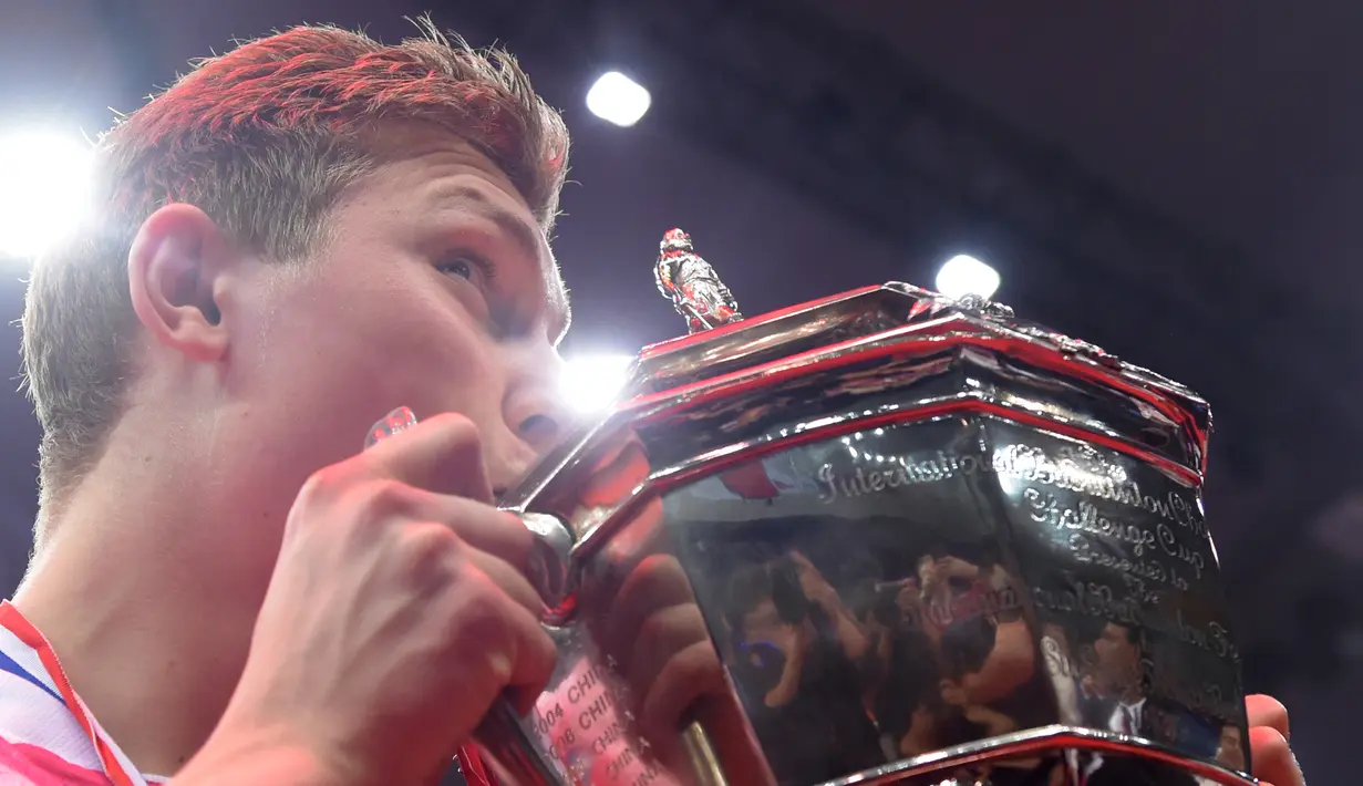 Viktor Axelsen mencium tropi Piala Thomas, China, Minggu (22/5). Kepastian kemenangan Denmark dipersembahkan Hans-Kristian Vitthingus setelah menang atas Ihsan Maulana Mustofa. (AFP Photo/Johannes Eisele)