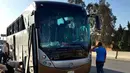 Petugas memeriksa sebuah bus wisata dan mobil yang rusak setelah ledakan bom di jalan dekat Piramida Giza, Kairo, Minggu (19/5/2019). Ledakan yang berasal dari bom pinggir jalan itu menghantam sebuah bus yang sedang melaju di Giza dan sebuah mobil di dekatnya. (AP Photo/Mohammed Salah)
