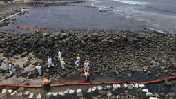 Pekerja melanjutkan kampanye pembersihan minyak di Pantai Pocitos, Ancon, Peru, 15 Februari 2022. Sebulan berlalu, pekerja melanjutkan pembersihan di pantai setelah terkontaminasi tumpahan minyak Repsol. (AP Photo/Martin Mejia)