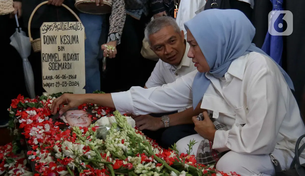 Kerabat dan saudara menabur bunga di makam Donny Kesuma di TPU Tanah Kusir, Jakarta, Rabu (20/3/2024). (Liputan6.com/Herman Zakharia)