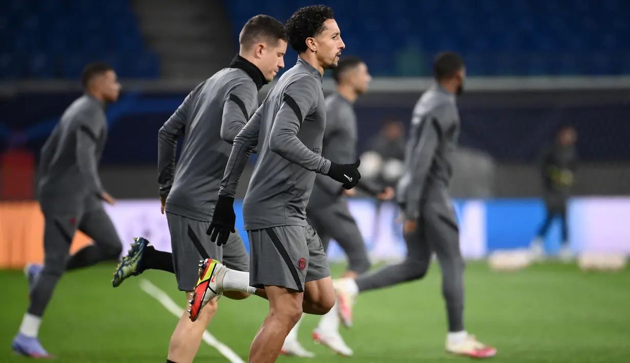 Bek PSG, Marquinhos dan rekan satu timnya melakukan pemanasan saat ambil bagian dalam sesi latihan di Leipzig, Jerman timur (2/11/2021). Tandang ke Leipzig, PSG tidak membawa Lionel Messi. (AFP/Franck Fife)