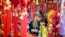 Seorang vendor menunggu pelanggan di kiosnya yang menjual dekorasi di Hong Kong (15/1/2021). Warga Hong Kong mulai berburu pernak-pernik Tahun Baru Imlek seperti lampion, kartu Imlek, baju, dan hiasan rumah. (AFP/Anthony Wallace)