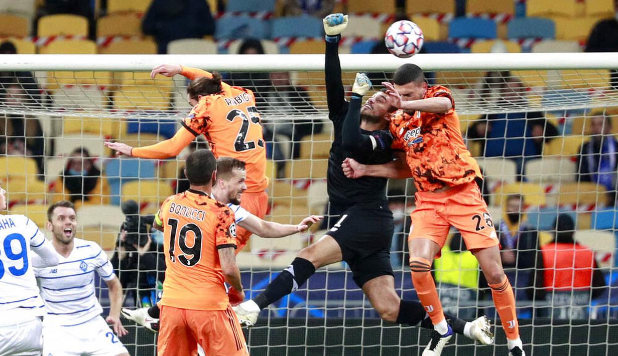 Pemain Juventus, Merih Demiral, duel udara dengan kiper Dynamo Kyiv, Heorhiy Bushchan, pada laga Liga Champions di Stadion Olimpiyskiy, Rabu (21/10/2020). Juventus menang dengan skor 2-0. (Valentyn Ogirenko/Pool via AP)