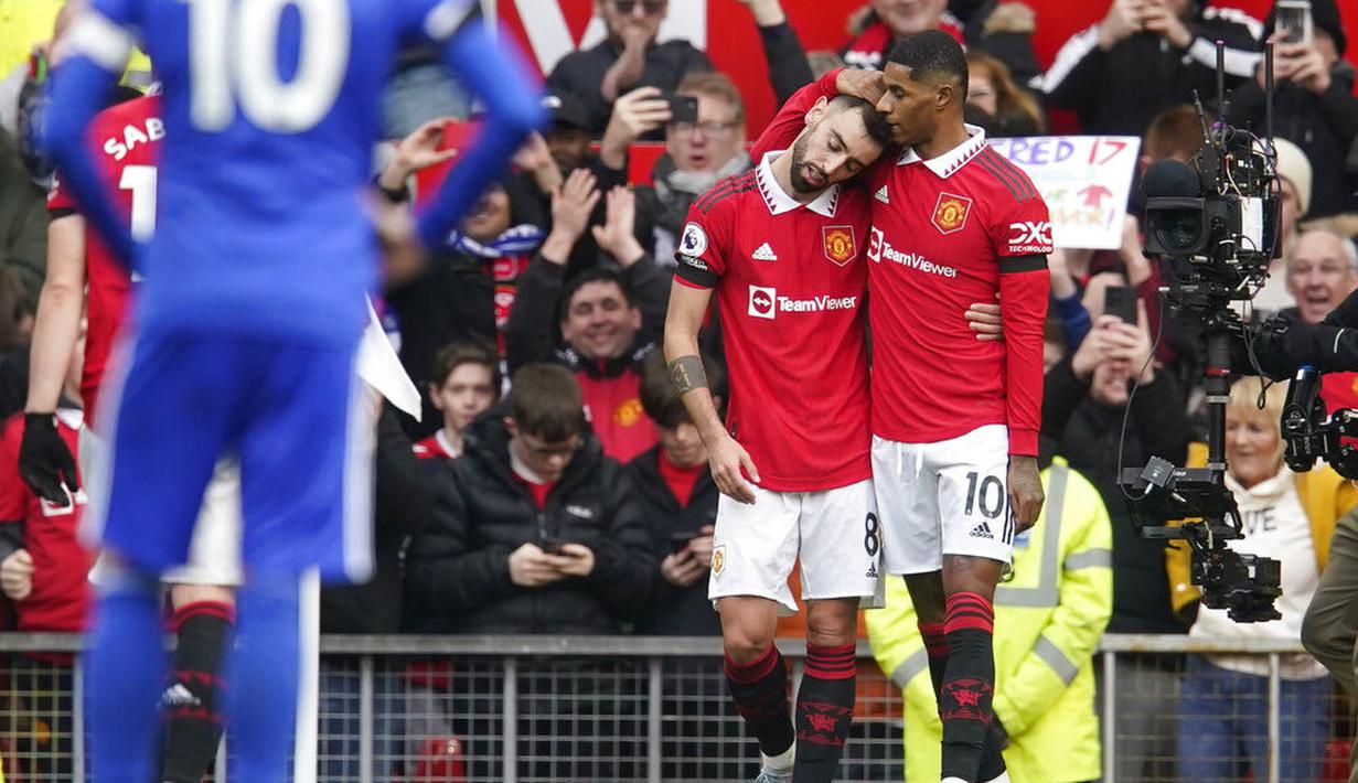 Pemain Manchester United, Marcus Rashford dan Bruno Fernandes merayakan gol yang dicetak ke gawang Leicester City pada laga Liga Inggris di Stadion Old Trafford, Minggu (19/2/2023). Marcus Rashford memborong dua dari tiga gol kemenangan Setan Merah. (AP Photo/Dave Thompson)