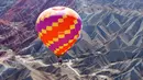 Sebuah balon udara terbang di langit Taman Geologi Nasional Danxia di Zhangye, Provinsi Gansu, China barat laut, pada 26 Juli 2020. Sebuah festival balon udara internasional dibuka di Zhangye pada Minggu (26/7). Total 100 balon udara akan ditampilkan dalam festival tersebut. (Xinhua/Cheng Lin)