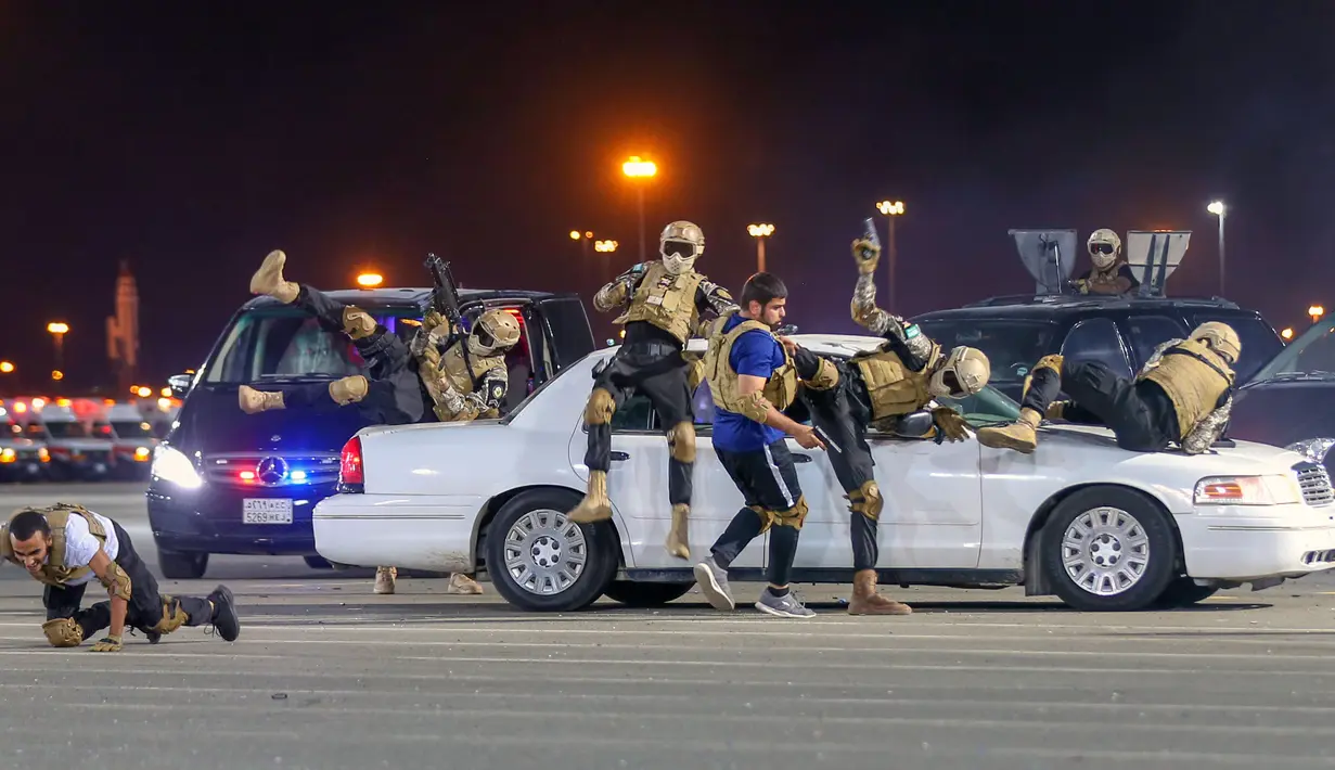 Anggota pasukan khusus Saudi  melakukan manuver keamanan dalam parade militer menjelang pelaksanaan puncak ibadah haji 2019 di Makkah, Arab Saudi, Minggu (4/8/2019). Salah satu acara di parade ini adalah memamerkan kesigapan pasukan elite Saudi melalui simulasi serangan teroris. (AFP Photo)