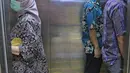 Sejumlah orang menaiki lift yang telah dipasangi garis batas dan saling membelakangi di PMI DKI Jakarta, Jumat (20/3/2020). PMI DKI Jakarta memberlakukan disiplin saling menjaga jarak atau social distancing sebagai langkah untuk mengantisipasi penyebaran COVID-19. (Liputan6.com/Herman Zakharia)