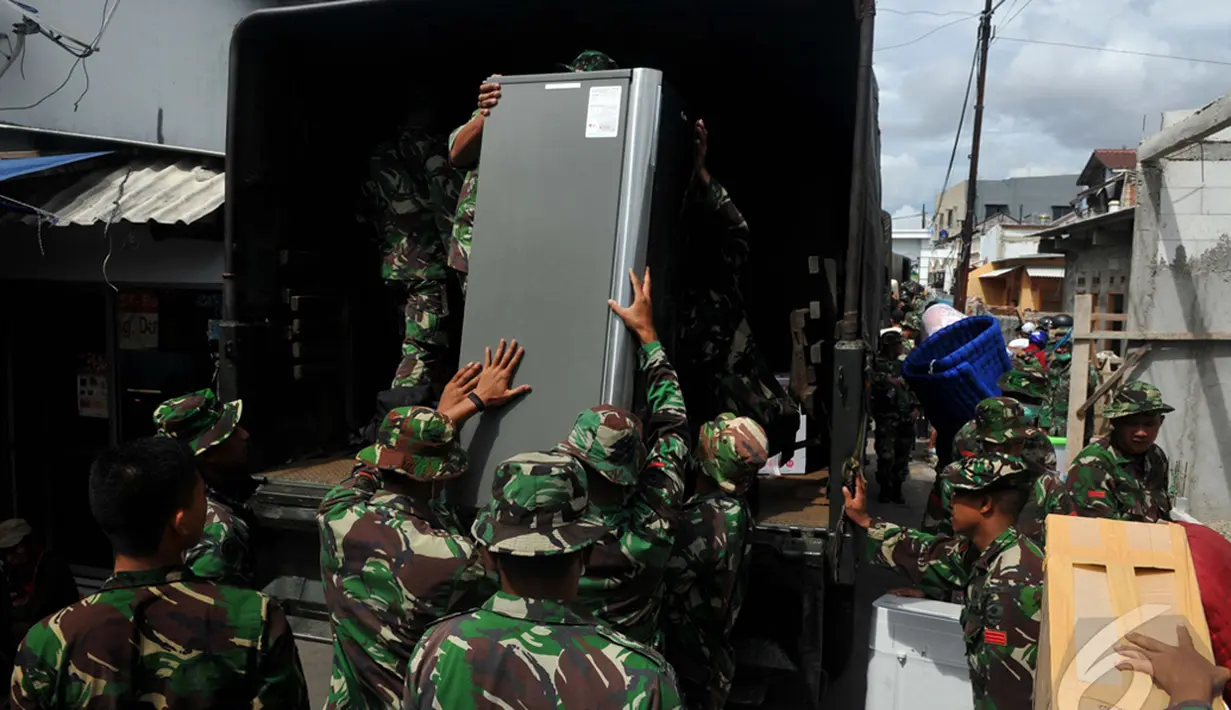 Personel TNI AD saat mengangkat barang milik warga ke atas truk ketika pembebasan Asrama Batalyon Siliwangi di Cililitan, Jakarta Timur, Kamis (8/1/2015). (Liputan6.com/Johan Tallo)