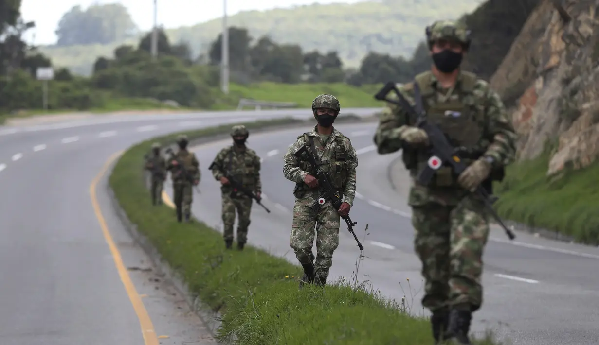 Tentara berpatroli di tengah lockdown yang diberlakukan kembali di pinggiran Bogota, Kolombia, Sabtu (10/4/2021). Kota-kota besar Kolombia memulai akhir pekan pertama lockdown ketat dalam upaya untuk mengurangi penyebaran gelombang ketiga virus corona. (AP Photo/Fernando Vergara)