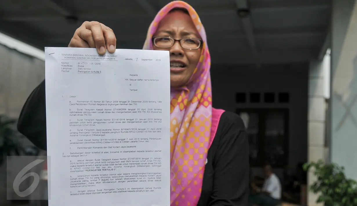 Warga perumahan Eks Yon Angkub, Cililitan Besar, Jakarta, menunjukan surat peringatan tertulis yang diberikan Kodam Jaya, Rabu (14/9). Warga di kawasan perumahan itu menolak eksekusi rumah yang akan dilakukan oleh Kodam Jaya. (Liputan6.com/Yoppy Renato)