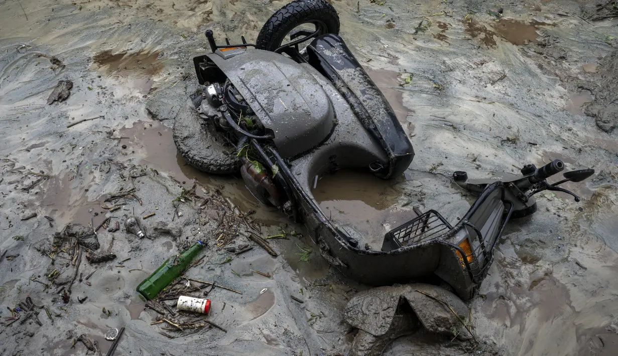 Sebuah skuter tergeletak di lumpur setelah tanah longsor yang disebabkan oleh hujan deras di Khaniyara, dekat Dharmsala, India (2/9/2022). Tidak ada korban jiwa yang dilaporkan akibat musibah tersebut. (AP Photo/Ashwini Bhatia)