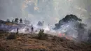 Relawan memadamkan api saat kebakaran hutan di Koycegiz, Mugla, Turki, Senin (9/8/2021). Kebakaran hutan yang terjadi di tengah gelombang panas ganas telah berkobar selama berhari-hari di lebih dari setengah provinsi Turki. (AP Photo/Emre Tazegul)