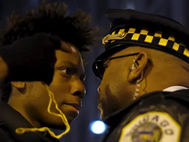 Massa bersitegang dengan polisi saat aksi protes di Chicago, Illinois, Rabu (25/11). Ketegangan rasial memanas setelah rilisnya video seorang polisi kulit putih menembak remaja kulit hitam, Laquan McDonald (17) pada Oktober 2014. (REUTERS/Andrew Nelles)