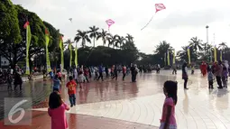 Sejumlah anak bermain layang layang di Lapangan Monumen Tugu Pancasila TMII, Jakarta, Jumat (8/7). TMII masih menjadi lokasi favorit warga menghabiskan libur hari raya. (Liputan6.com/Helmi Fithriansyah)