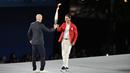 Petenis asal Spanyol, Rafael Nadal, menerima obor dari legenda Prancis, Zinedine Zidane, dalam acara pembukaan Olimpiade Paris 2024 di Sungai Seine, Prancis. (AP Photo/Natacha Pisarenko)