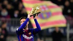 Lionel Messi menunjukkan Sepatu Emas Eropa sebelum melawan Deportivo La Coruna dalam pertandingan liga Spanyol di stadion Camp Nou di Barcelona (17/12). Messi meraih Sepatu Emas usai menjadi pencetak gol terbanyak di Eropa. (AFP Photo/Javier Soriano)