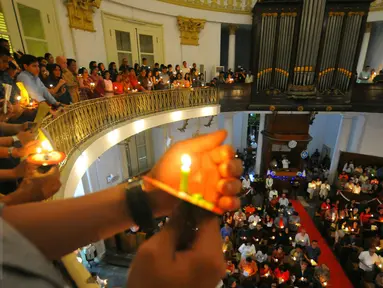 Umat Kristiani menyalakan lilin pada misa malam Natal di Gereja Immanuel, Jakarta  Sabtu (24/12). Perayaan natal berlangsung khidmat. (Liputan6.com/Angga Yuniar)