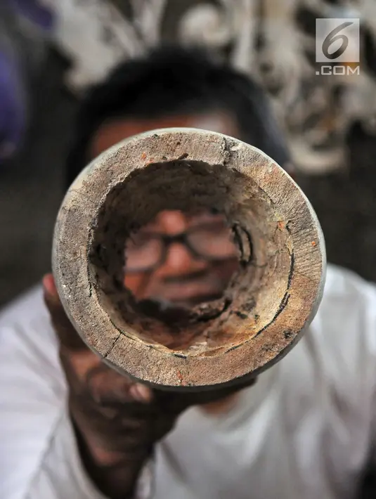 Perajin Oman Sumarna menyelesaikan pembuatan patung di Sanggar Primitif, Sawangan, Depok, Jawa Barat, Rabu (9/1). Harga patung-patung buatan Oman itu dijual dengan harga bervariasi tergantung tingkat kesulitan pembuatannya. (Liputan6.com/Herman Zakharia)