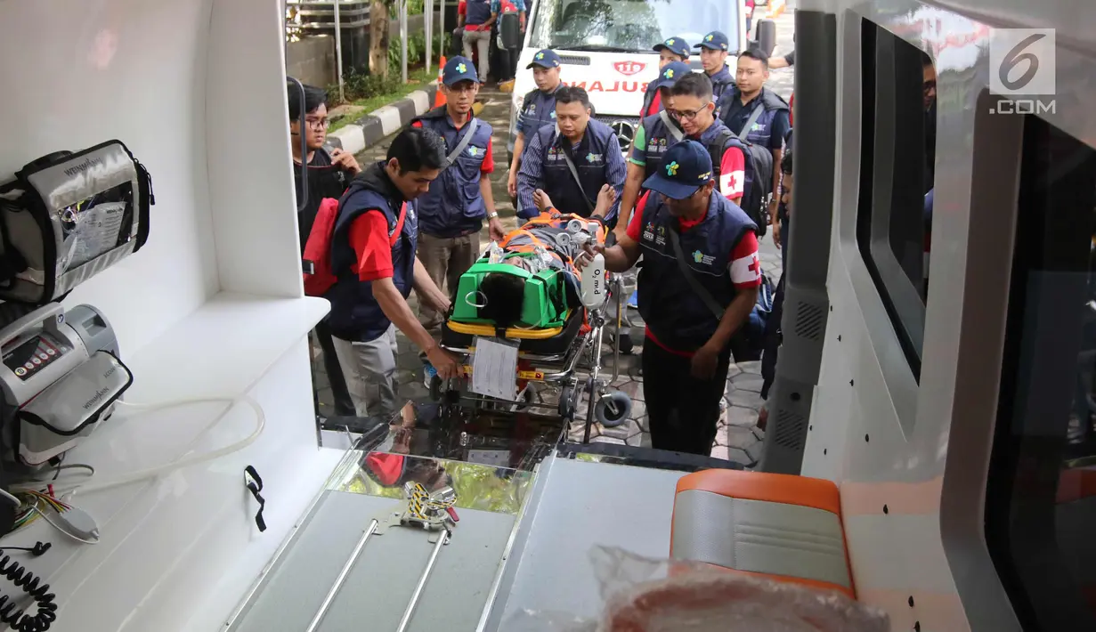 Sejumlah tenaga medis membawa atlet Asian Games 2018 ke dalam mobil ambulan selama simulasi penanganan cedera di Kantor Kemenkes, Jakarta, Rabu (4/4). Simulasi ini melibatkan sejumlah dokter, perawat, dan fisioterapis.  (Liputan6.com/Arya Manggala)