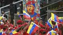 Pendukung membawa gambar mendiang mantan Presiden Hugo Chavez selama parade militer menandai Hari Kemerdekaan di Caracas, Venezuela, Senin (5/7/2021). Venezuela menandai 210 tahun deklarasi kemerdekaan mereka dari Spanyol. (AP Photo/Matias Delacroix)