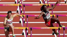 Atlet asal Trinidad dan Tobago, Deborah John (kanan) kehilangan keseimbangan saat melewati rintangan kelima dalam cabang lari halang rintang 100 meter putri Kejuaraan Atletik Dunia yang digelar di Stadion London, Inggris (11/8). (Jonathan Brady/PA via AP)