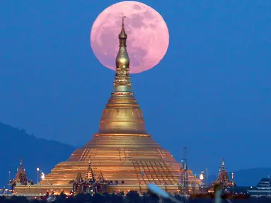 Penampakan fenomena supermoon dari balik pagoda Uppatasanti di langit Naypyitaw, Myanmar, Minggu (3/12). Supermoon adalah istilah populer untuk menyebut purnama yang posisi orbit Bulan sedang berada di jarak terdekat dengan Bumi. (AP/Aung Shine Oo)