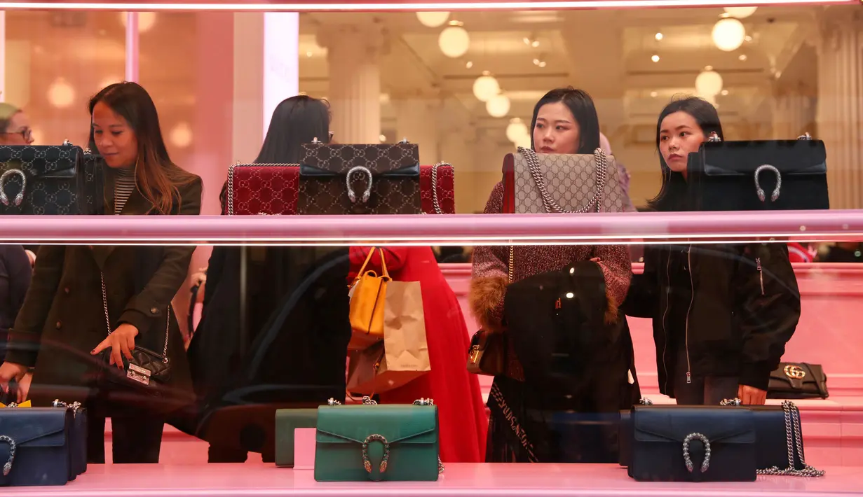 Calon pembeli melihat-lihat tas selama Boxing Day di Selfridges, Oxford Street, London, Rabu (26/12). Boxing Day merupakan tradisi hari belanja terbesar tahunan yang dirayakan sehari setelah hari Natal. (Isabel Infantes/PA via AP)