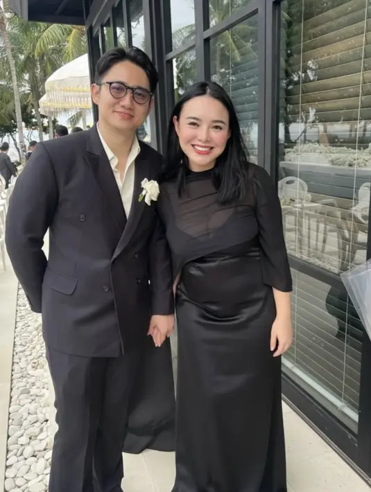 Amanda Manopo hadir bersama suaminya, Kenny Austin yang didapuk menjadi groomsmen. Amanda Manopo tampil dengan long dress hitam spaghetti strap ditutup kain sheer hitam. Kenny tampil gagah mengenakan setelan jas hitam hitam. [@harinisondakh]