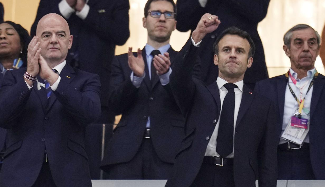 Emmanuel Macron tampak duduk di sebelah Presiden FIFA, Gianni Infantino. (AP Photo/Manu Fernandez)