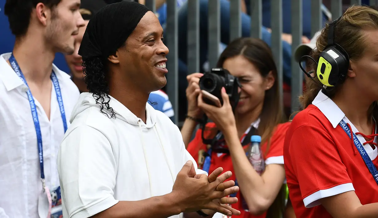 Legenda sepakbola Brasil, Ronaldinho menghadiri seremonial final Piala Dunia 2018 antara Prancis vs Kroasia di Stadion Luzhniki, Minggu (15/7). Ronaldinho sukses menghadirkan kemeriahan sebelum laga final bergulir. (AFP/FRANCK FIFE)